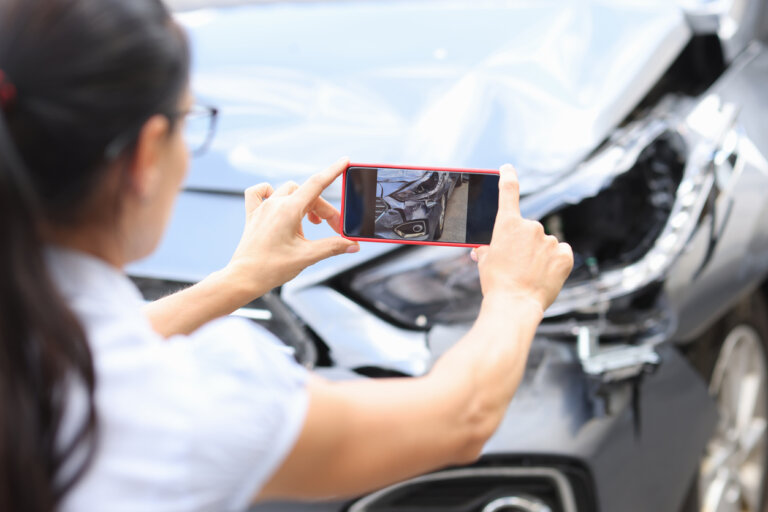 woman taking photo of car accident